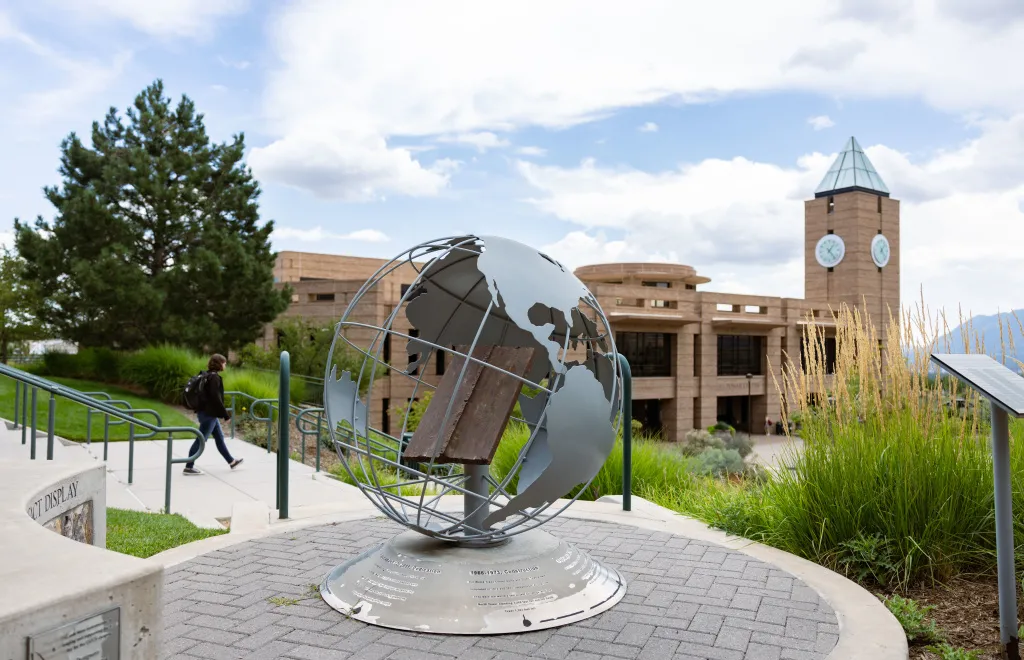 globe statue in front of el pomar clock tower on uccs campus